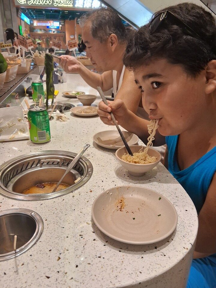 Mark and Feng eating hot pot