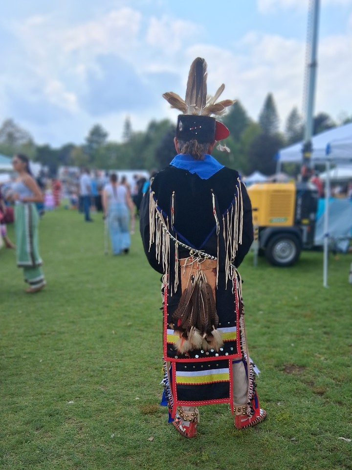 Dancer performing as other participants in regalia watch from the sidelines — Akwesasne International Powwow, Sept. 13, 2026, Lamoureux Park, Cornwall, Ontario, Canada