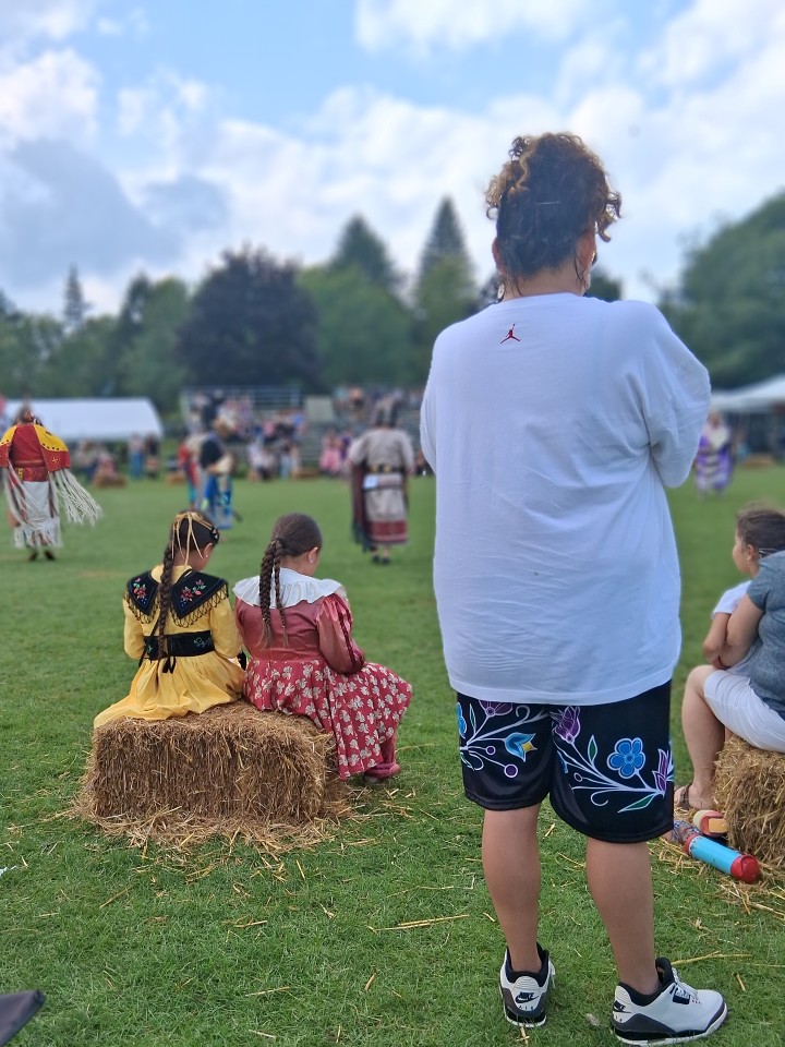 Dancers performing as other participants in regalia watch from the sidelines — Akwesasne International Powwow, Sept. 13, 2026, Lamoureux Park, Cornwall, Ontario, Canada