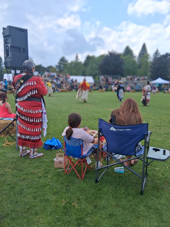 Dancers performing as other participants in regalia watch from the sidelines — Akwesasne International Powwow, Sept. 13, 2026, Lamoureux Park, Cornwall, Ontario, Canada