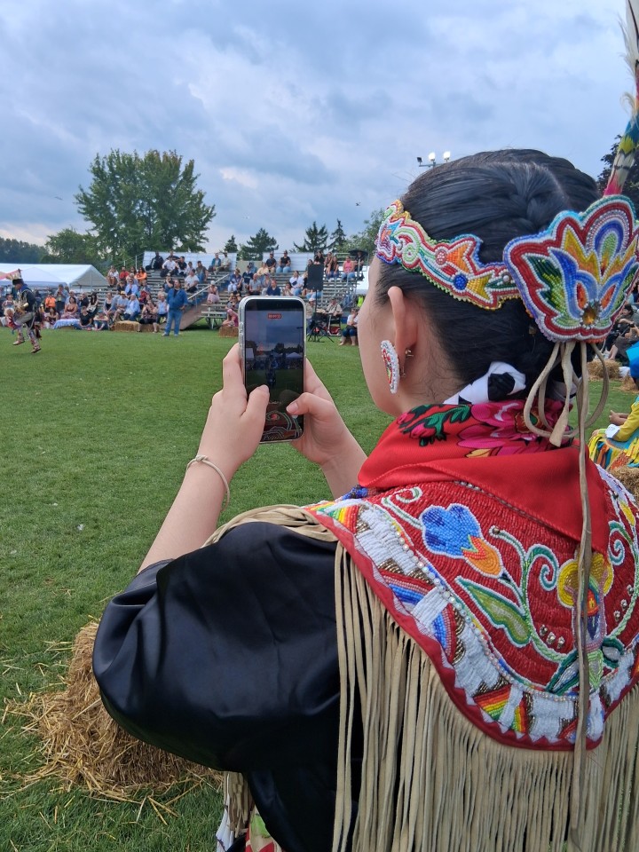 Dancers performing as other participants in regalia watch from the sidelines — Akwesasne International Powwow, Sept. 13, 2026, Lamoureux Park, Cornwall, Ontario, Canada