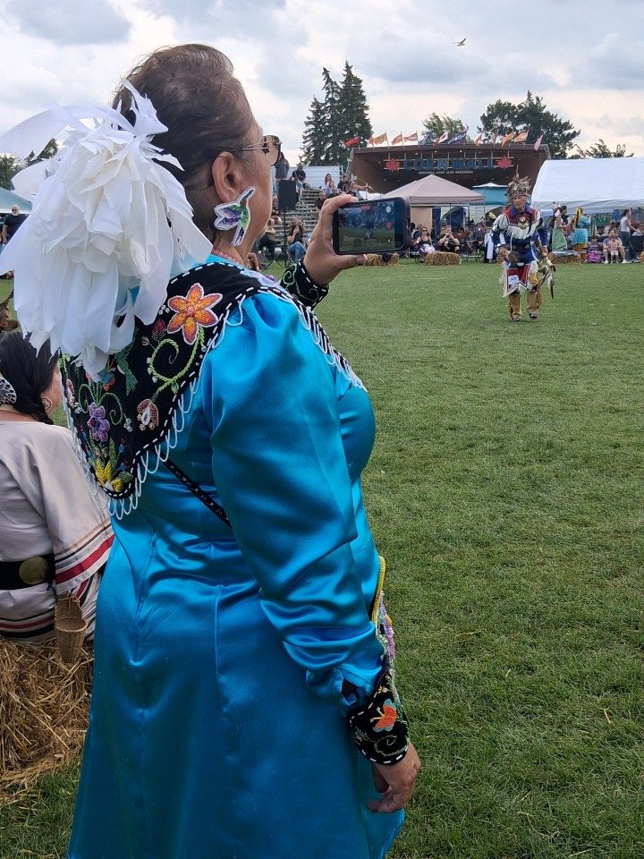 Dancers performing as other participants in regalia watch from the sidelines — Akwesasne International Powwow, Sept. 13, 2026, Lamoureux Park, Cornwall, Ontario, Canada