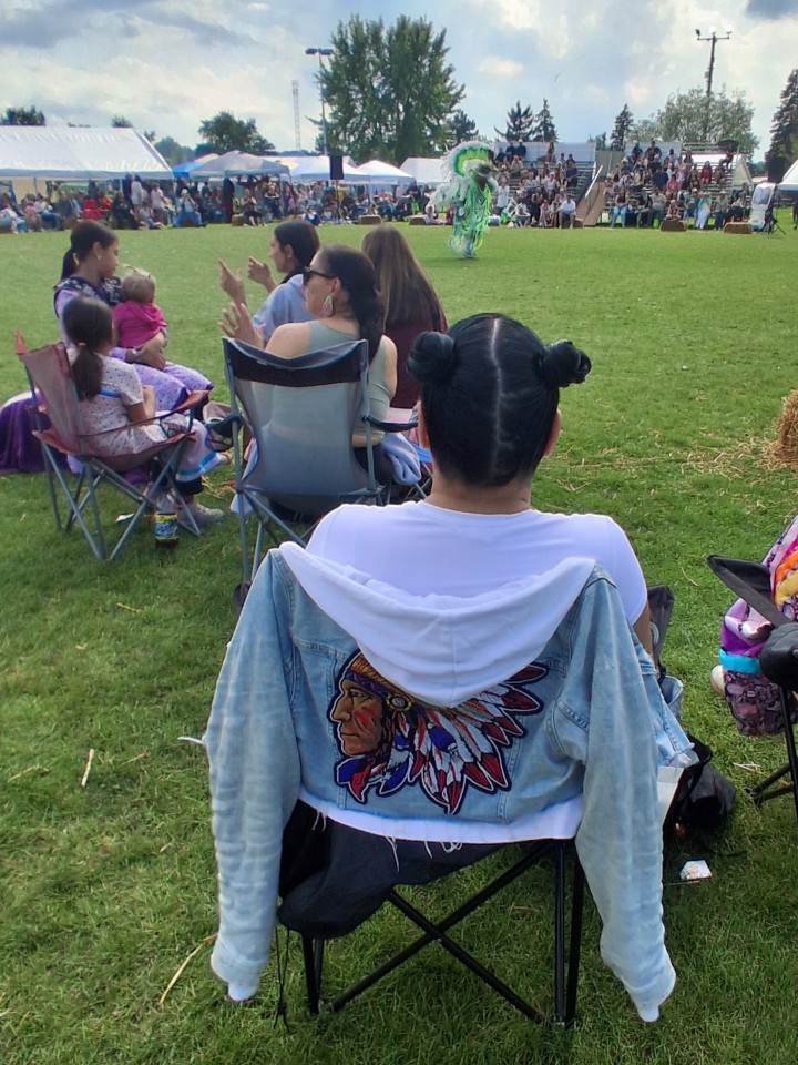 Dancers performing as other participants in regalia watch from the sidelines — Akwesasne International Powwow, Sept. 13, 2026, Lamoureux Park, Cornwall, Ontario, Canada