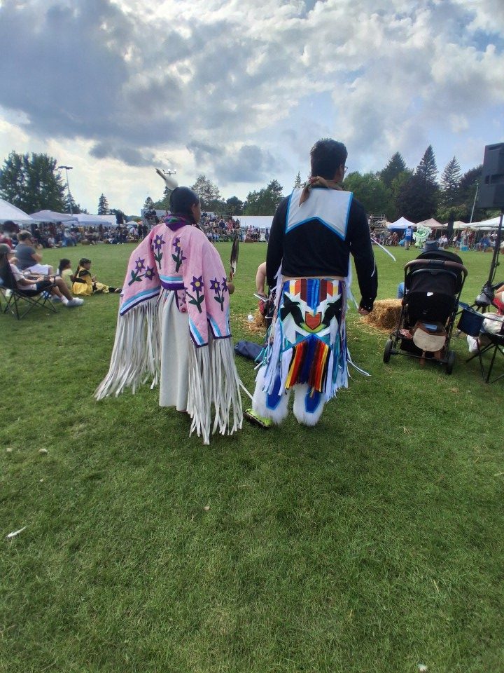 Dancers performing as other participants in regalia watch from the sidelines — Akwesasne International Powwow, Sept. 13, 2026, Lamoureux Park, Cornwall, Ontario, Canada