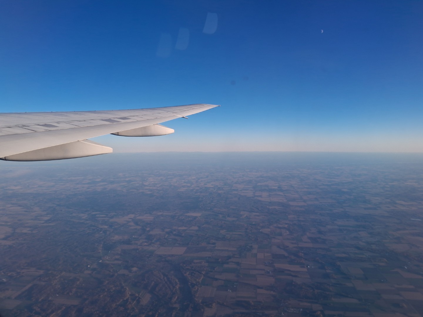 Patchwork fields stretching to the horizon as we climb away from Ottawa — Oct. 17, 2026, Ontario, Canada