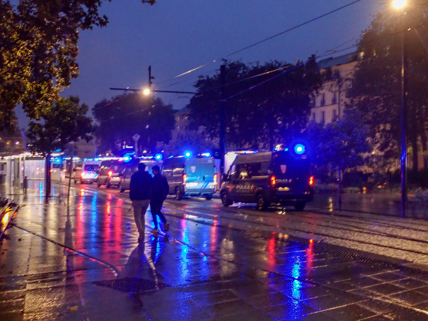 CRS vans still lining the tram tracks after dark — Oct. 24, 2026, Nantes, Pays de la Loire, France